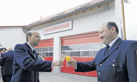 Wehrführer Rüdiger Linder und stellvertretender Wehrführer Jürgen Lang stoßen auf das neue Feuerwehrhaus an